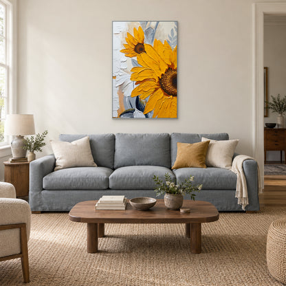 Yellow sunflower artwork in a silver-tone frame centred above a grey-blue sofa with cream and ochre cushions