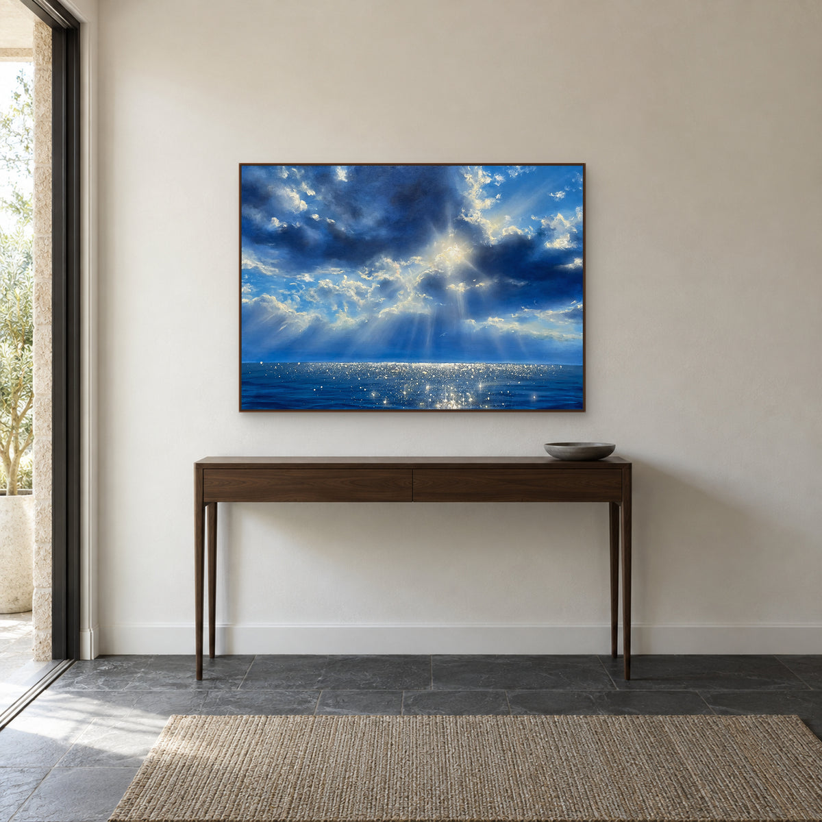 Rêverie bleue dans un cadre flottant couleur noyer, au-dessus d’une étroite console en bois dans une entrée.
