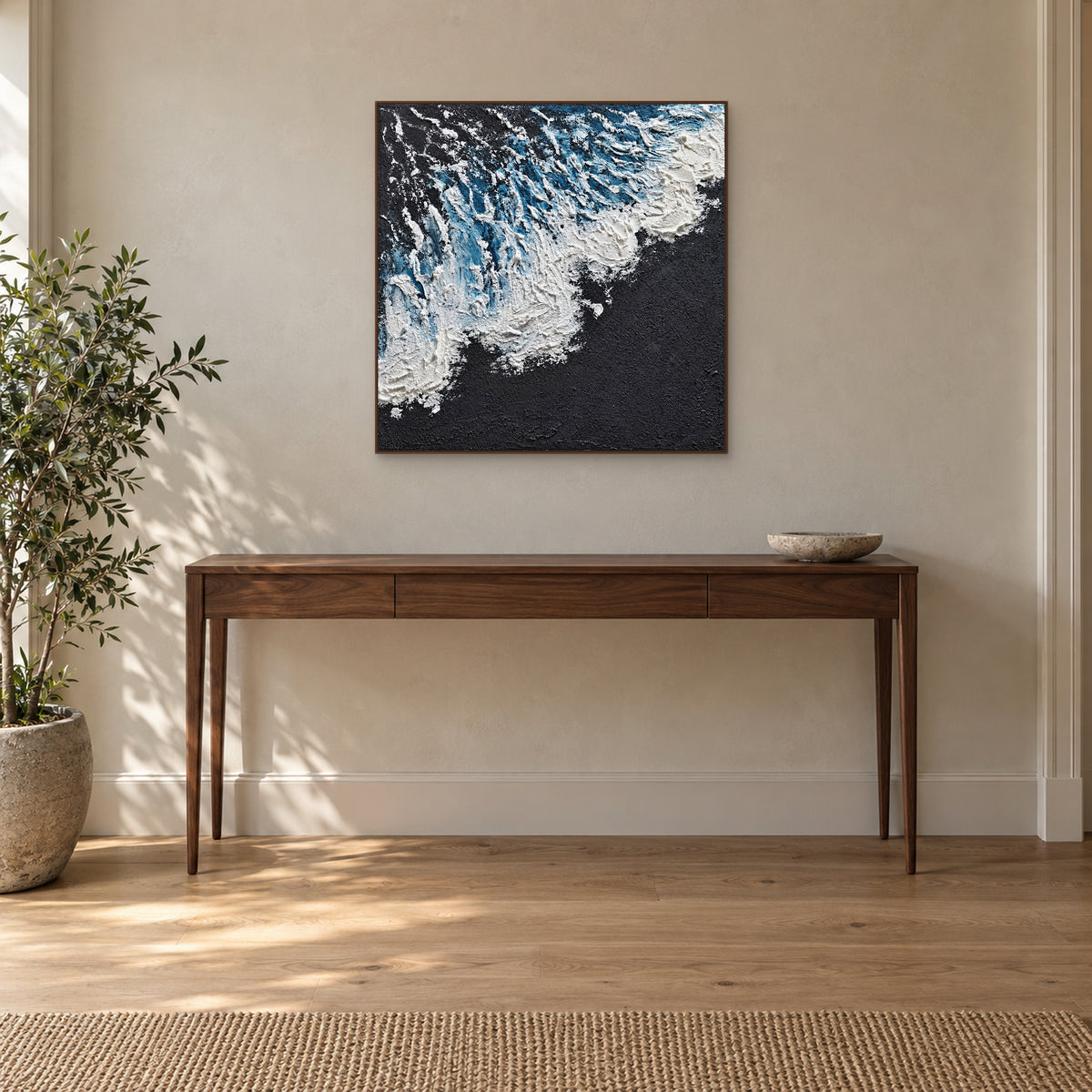 Textured white surf on dark ground in a walnut-tone frame above a dark wooden console