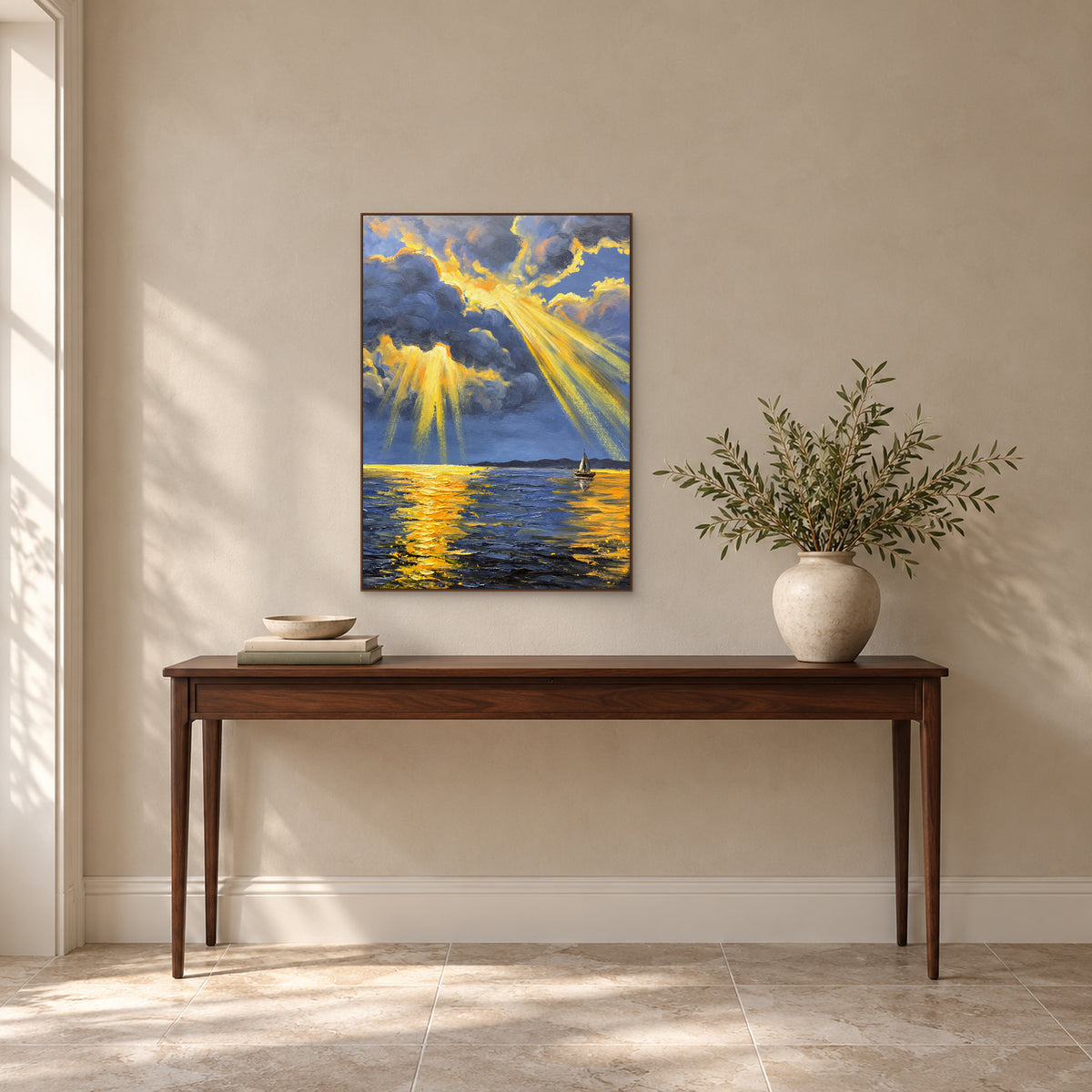 Rayons dorés sur l’eau bleue, dans un cadre ton noyer au-dessus d’une console, avec des branches feuillues à droite.