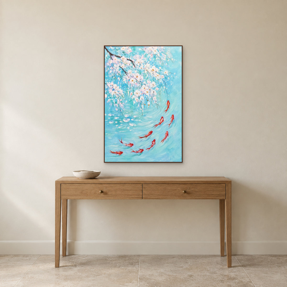 Tableau de carpes et de fleurs blanches dans un cadre flottant couleur noyer, centré au-dessus d’une fine console en chêne sur un mur ivoire.