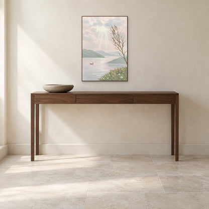 Soft pink lake painting in a walnut-tone frame above a narrow entryway console