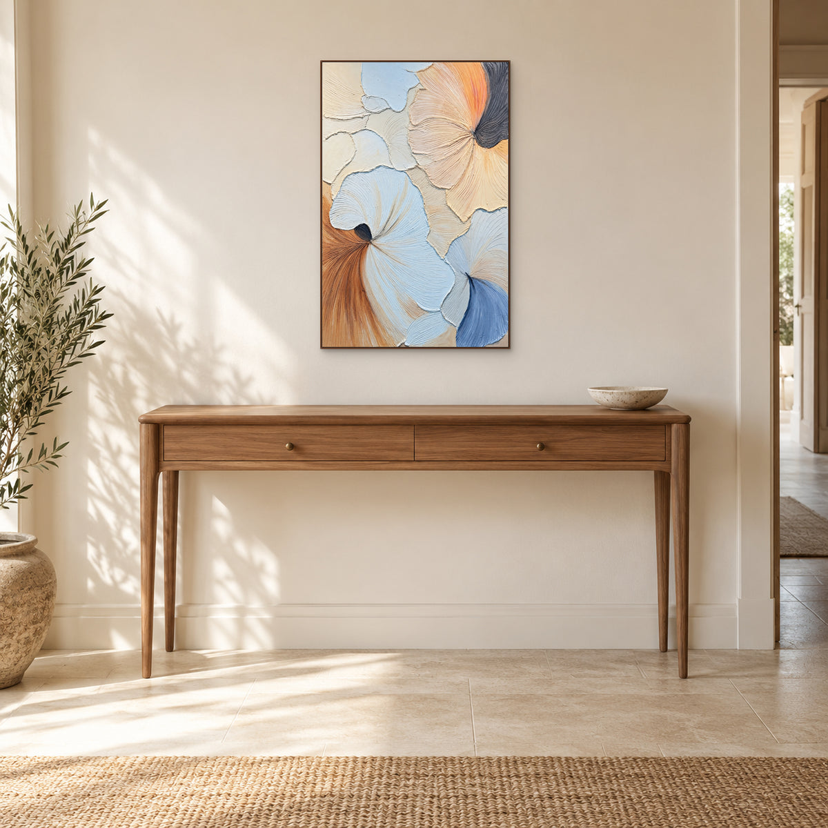 Tableau en relief bleu, pêche et crème, cadre couleur noyer, centré au-dessus d’une console en bois dans l’entrée