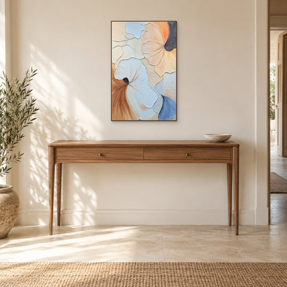 Tableau en relief bleu, pêche et crème, cadre couleur noyer, centré au-dessus d’une console en bois dans l’entrée