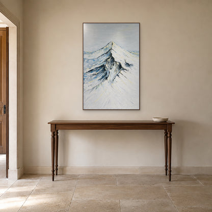 Tableau vertical de montagne enneigée dans un cadre ton noyer au-dessus d'une console d'entrée