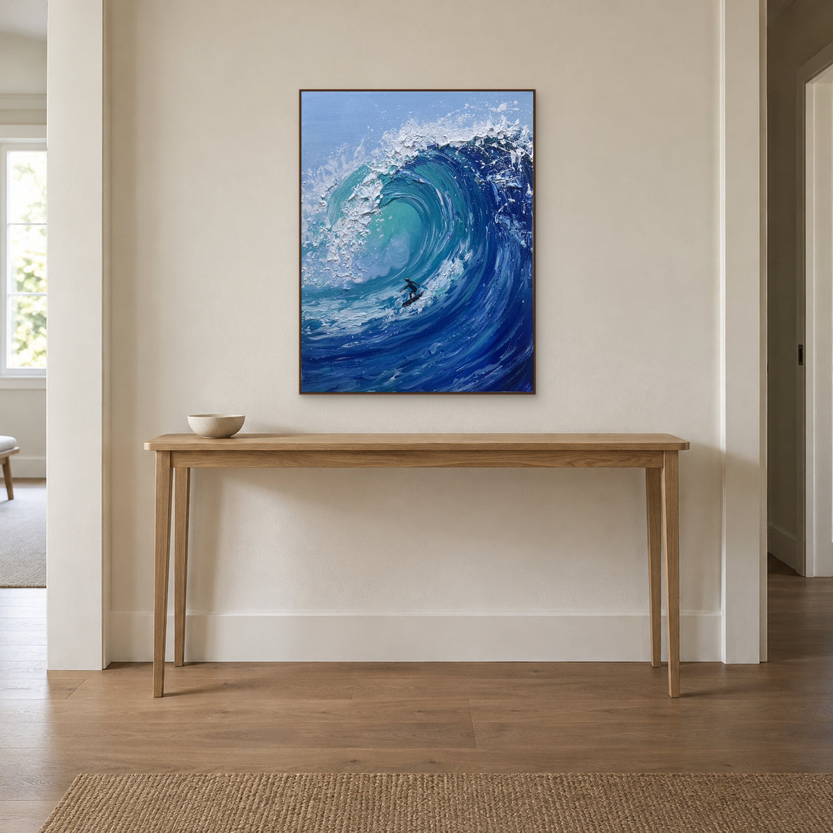 Tableau de surfeur dans un cadre ton noyer, centré au-dessus d’une console en bois dans une entrée
