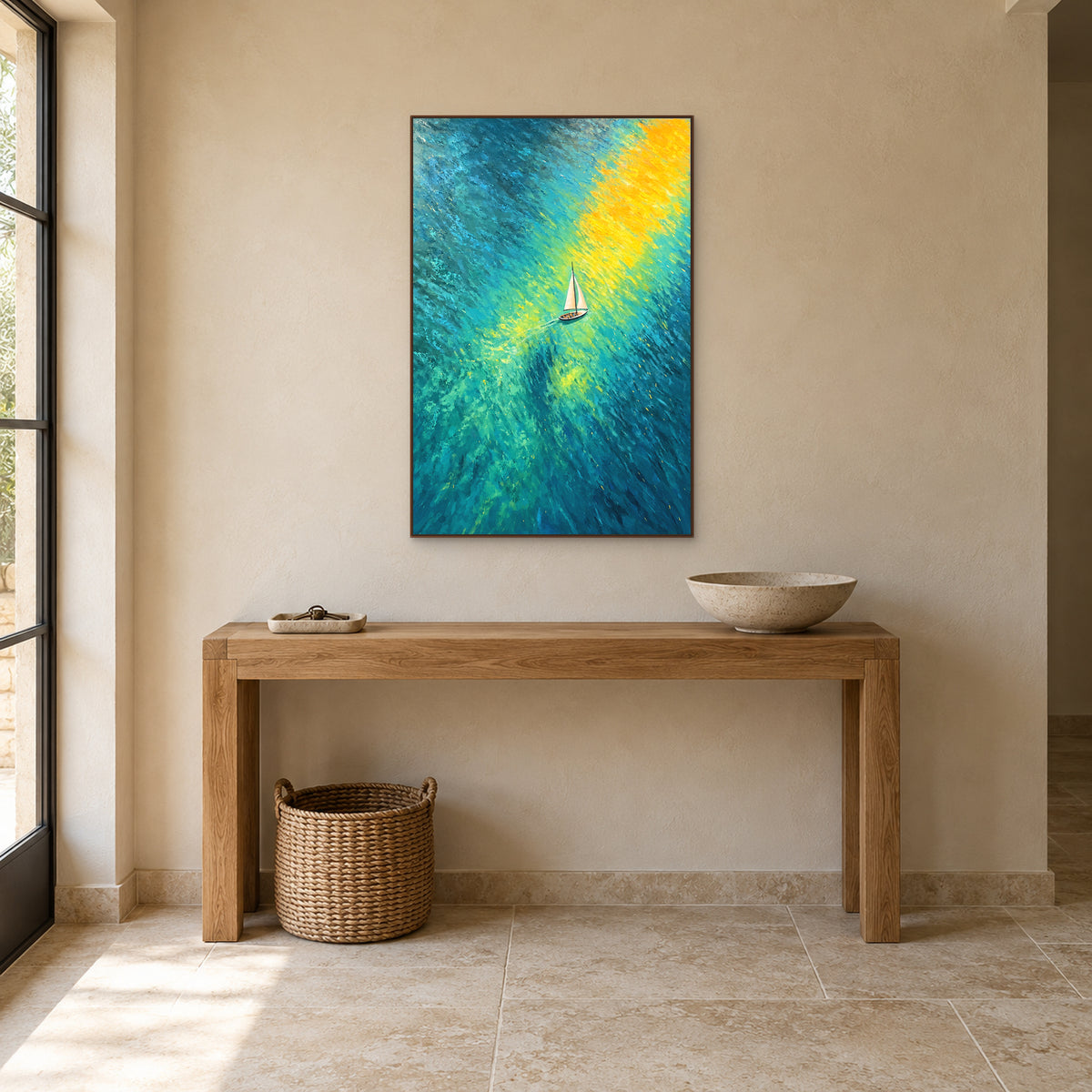 Tableau vertical de voilier et de lumière jaune sur une eau bleu-vert, cadre ton noyer au-dessus d’une console en chêne.