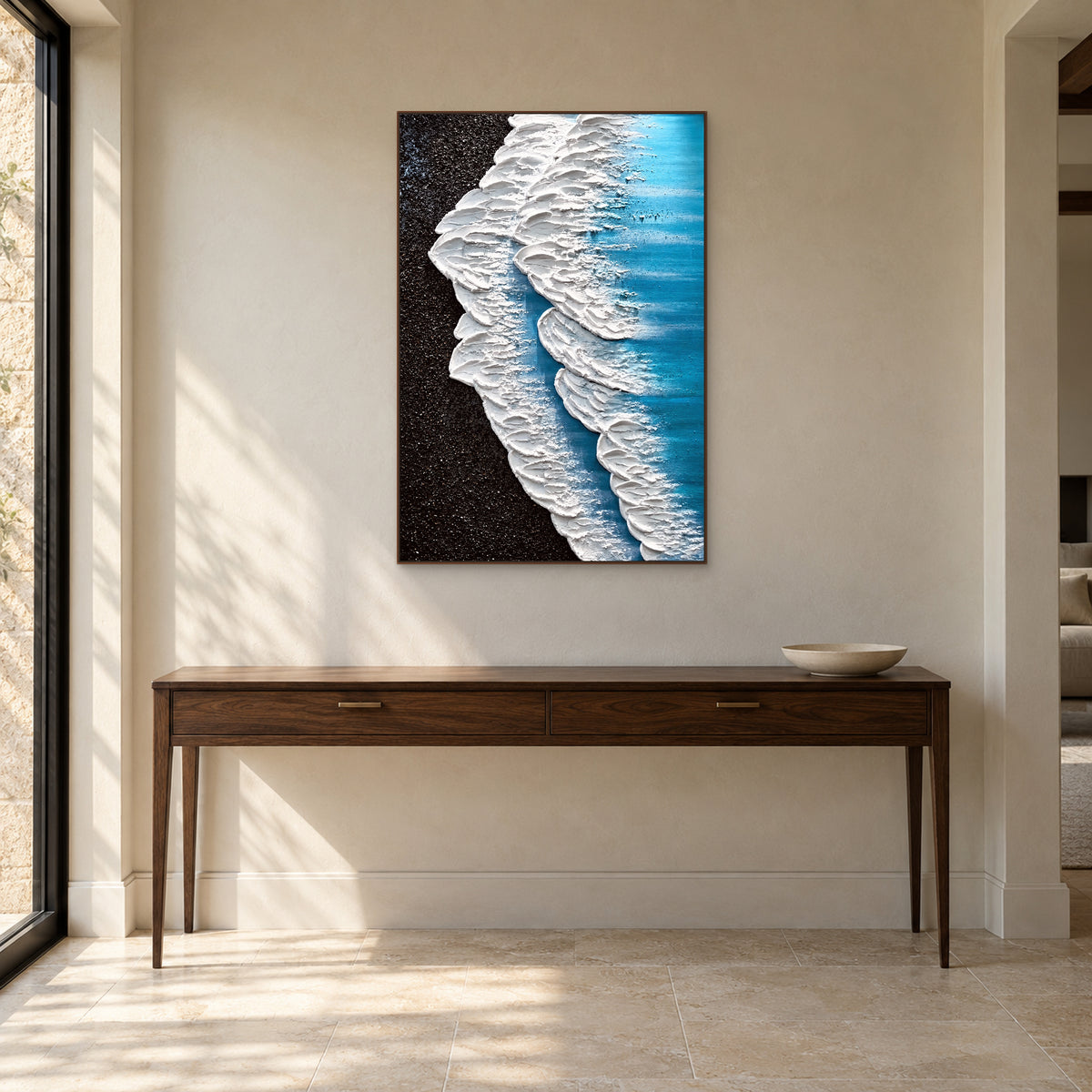 Tableau d’écume et de rivage sombre dans un cadre ton noyer au-dessus d’une console avec une coupe basse