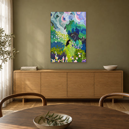 Colourful black cat garden painting in a champagne-toned floating frame above a honey-toned wood sideboard beside a dining table