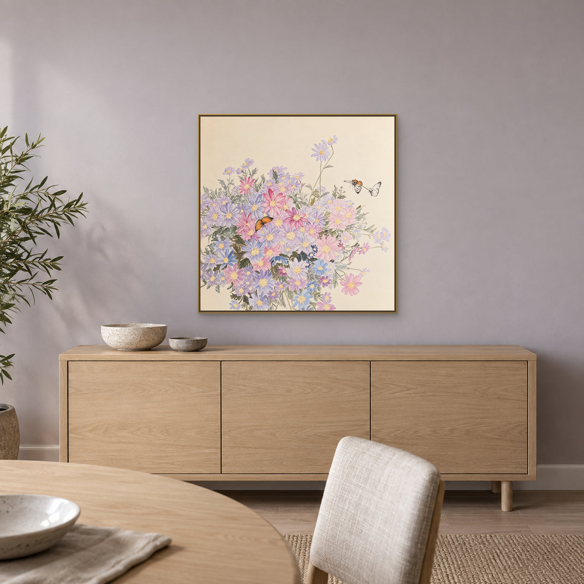 Square wildflower painting in a champagne-look floating frame above an oak dining sideboard