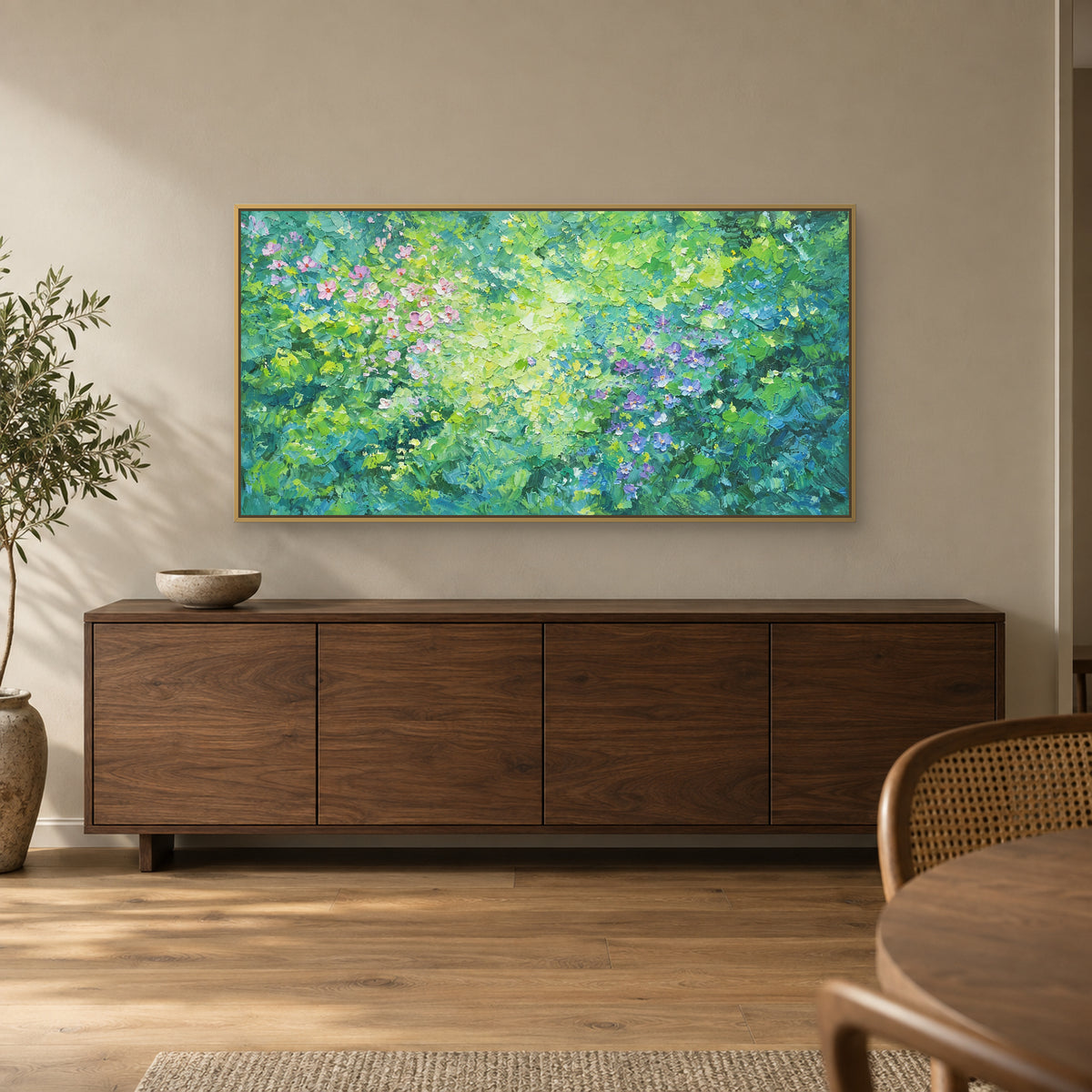 Tableau floral vert et violet dans un cadre flottant champagne, au-dessus d’un buffet en bois sombre près d’une chaise cannée