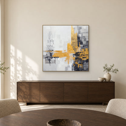 Tableau abstrait doré et charbon dans un cadre champagne au-dessus d’un buffet en chêne sombre, derrière une table ronde