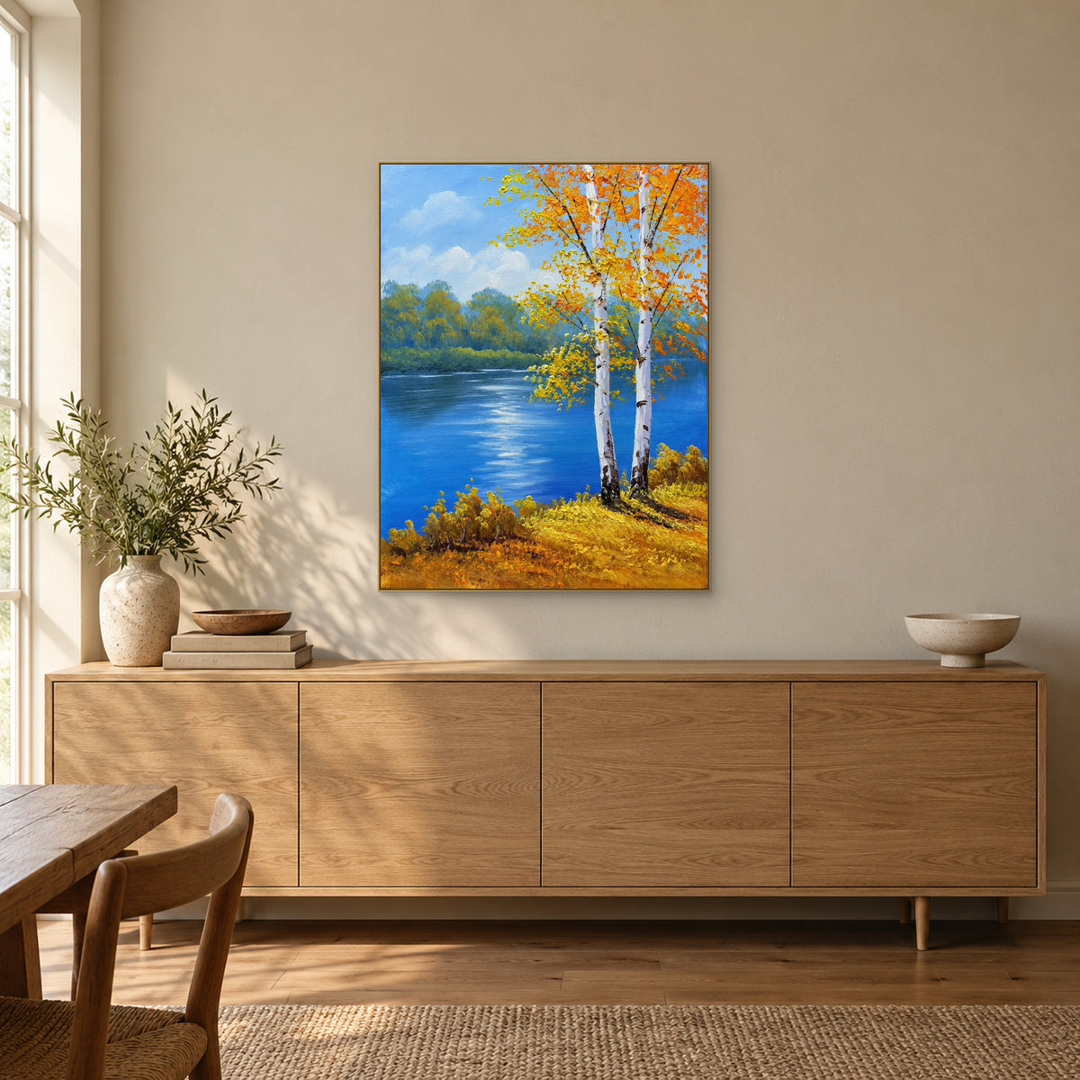 Bouleaux au bord d’une rivière bleue à cadre couleur champagne, au-dessus d’un buffet en bois