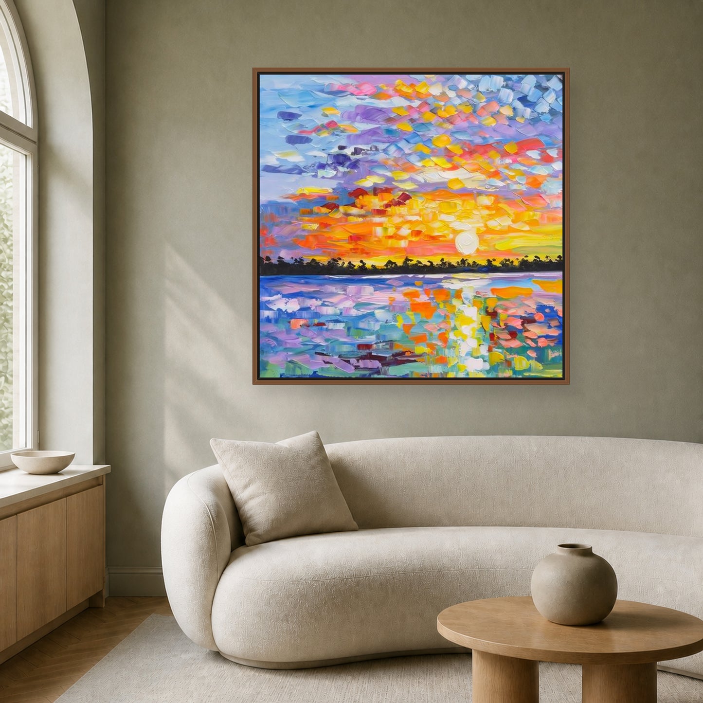 Colorful square sunset painting in a slim wood floating frame above an ivory curved sofa