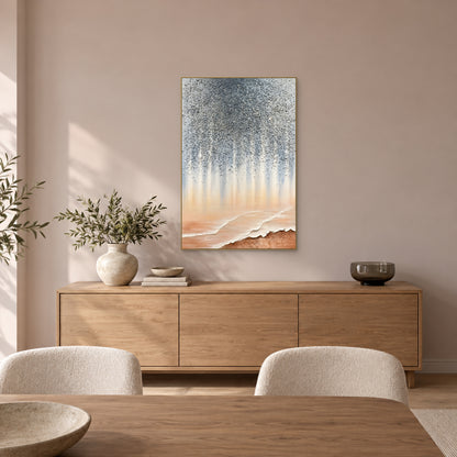 Grey flecks and peach shoreline forms in a champagne-toned frame above an oak sideboard in a softly lit dining room