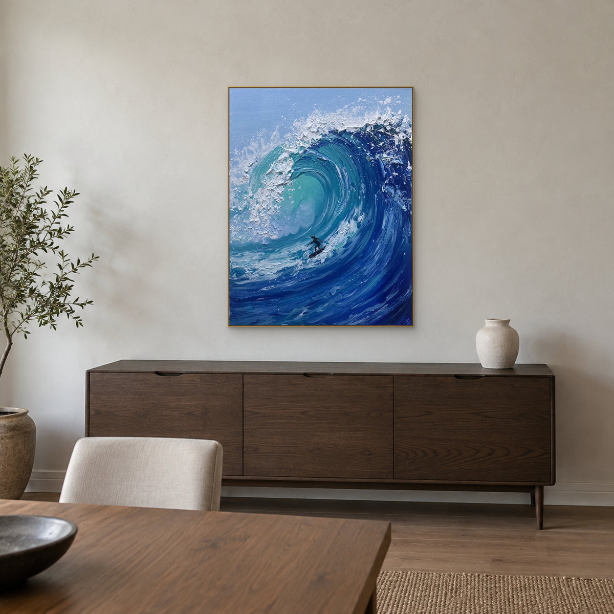 Vague turquoise et surfeur dans un cadre champagne, au-dessus d’un buffet en bois foncé dans une salle à manger