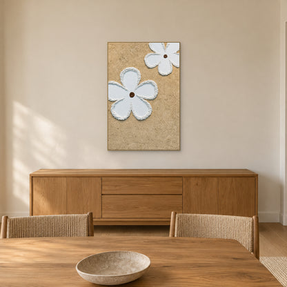 Fleurs blanches sur fond beige granuleux à cadre couleur champagne, au-dessus d’un buffet de salle à manger en bois