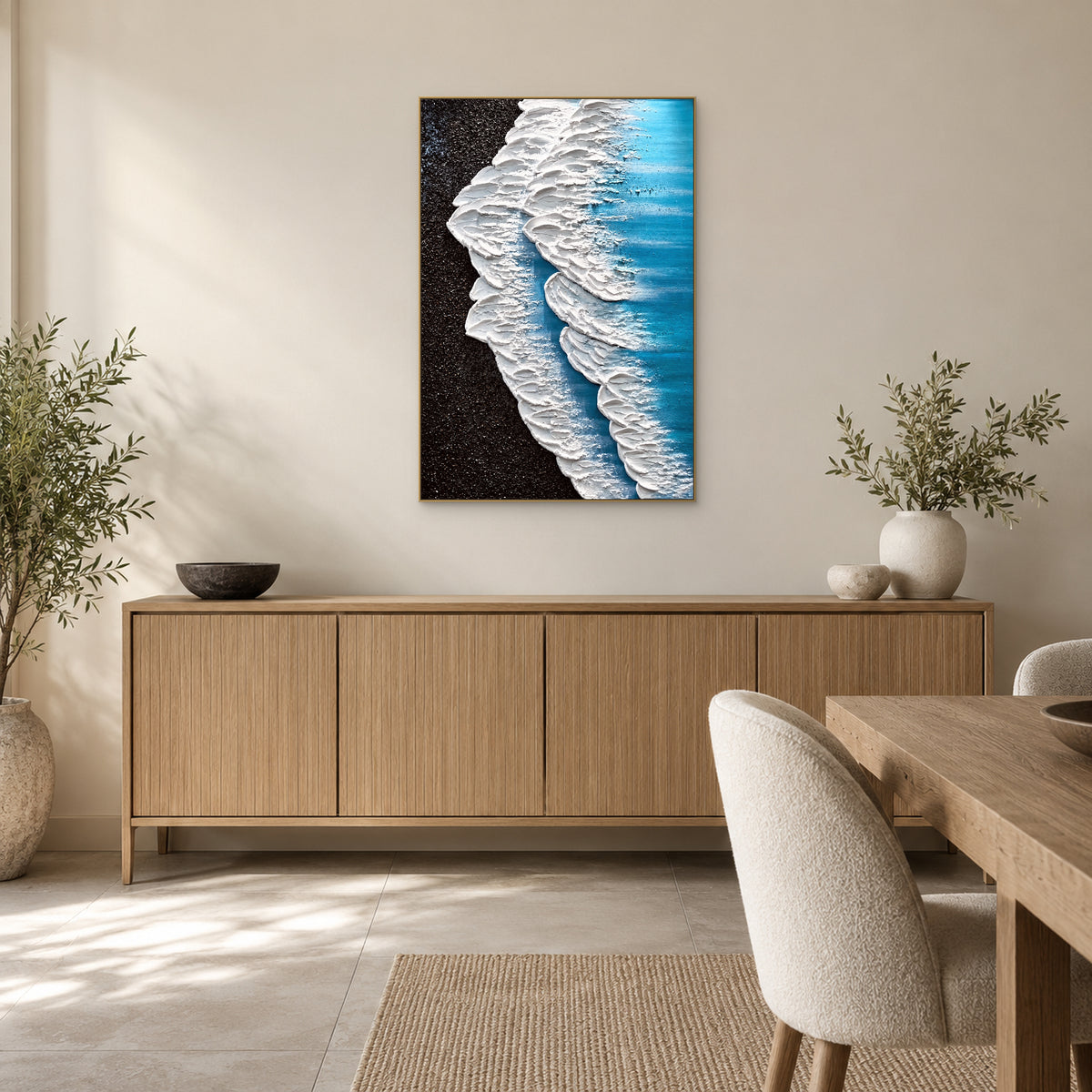 Tableau de vagues vertical dans un cadre champagne, au-dessus d’un buffet en bois près d’une table à manger