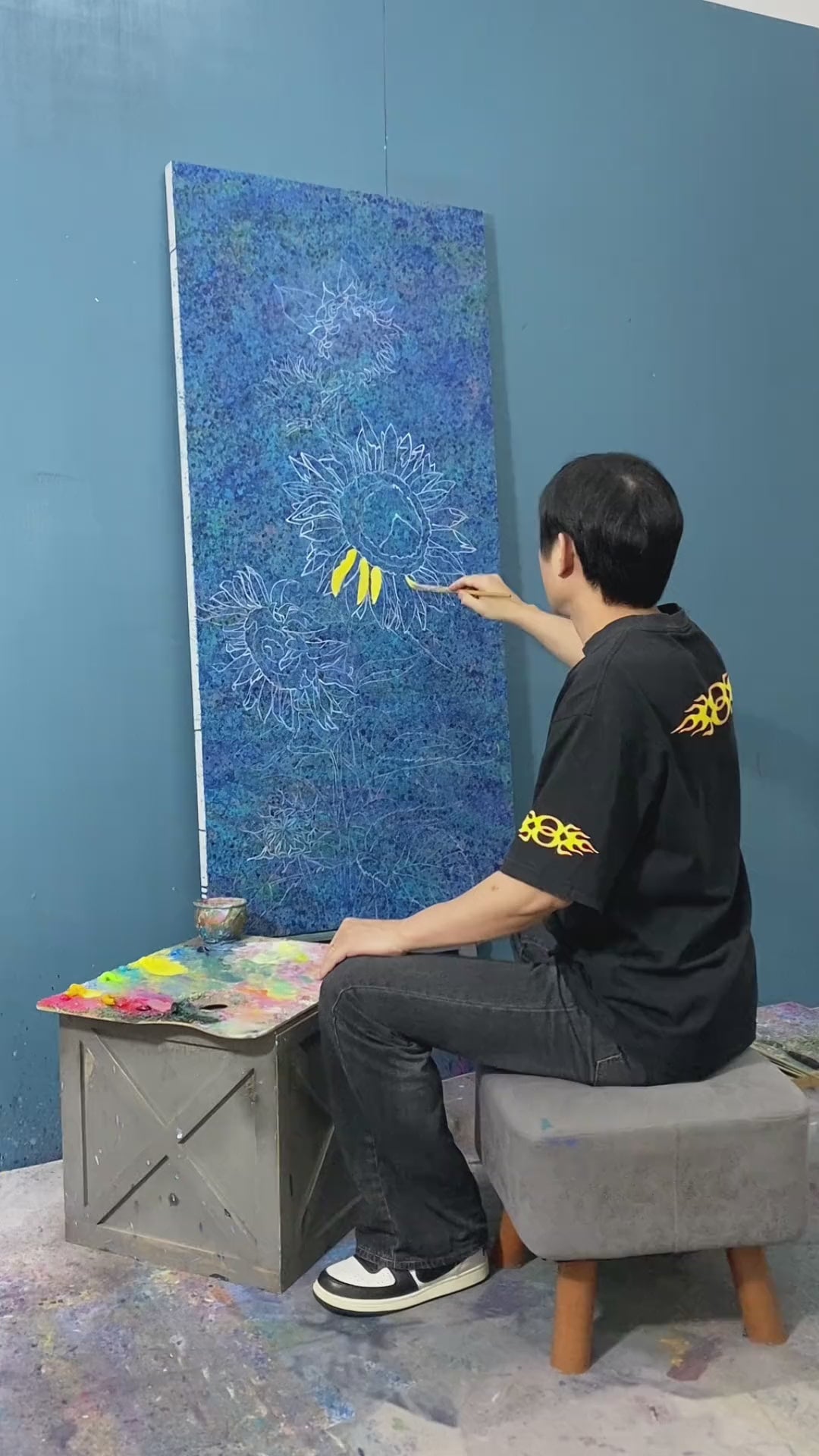Painting sunflower petals, leaves and flower centres, followed by a frontal view of the completed blue-ground canvas